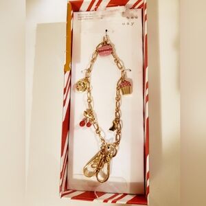 a new day Pastry Bow & Cherry Charm Phone Strap or Wristlet in a gold-tone New
